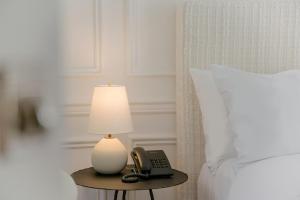a lamp and a phone on a table next to a bed at Cara Hotel in Los Angeles