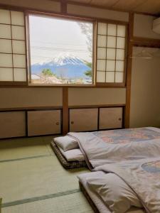 a bed room with two beds and a window at Togawaso in Fujikawaguchiko