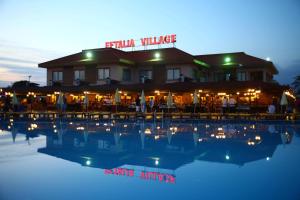 un hotel con piscina frente a un edificio en Eftalia Holiday Village, en Konaklı