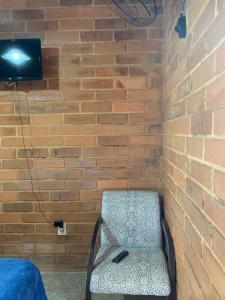 a chair in a room with a brick wall at Casa João de Barro - São Pedro da Serra in Nova Friburgo