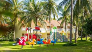 een speeltuin voor een resort met palmbomen bij Saigon Mui Ne Resort in Mũi Né
