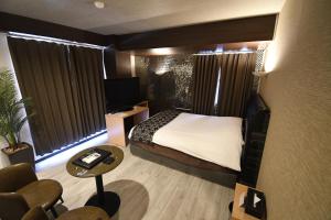 a hotel room with a bed and a desk and a television at Matsudo Grand Hotel in Matsudo
