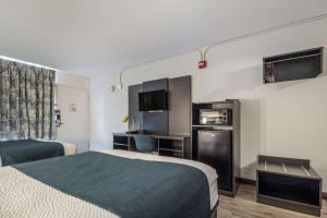 um quarto de hotel com duas camas e uma cozinha em Motel 6 Groves, Tx em Groves