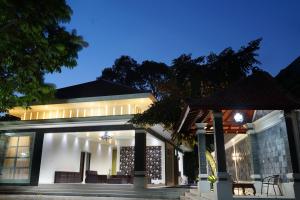 une maison avec une façade éclairée la nuit dans l'établissement Villa Sanlias, à Bogor