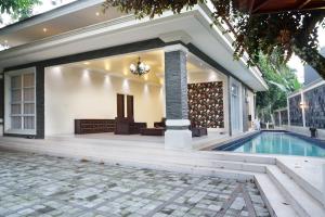a house with a swimming pool and a patio at Villa Sanlias in Bogor