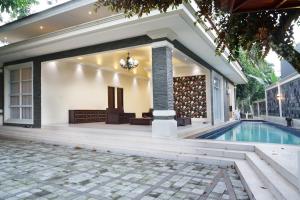 a house with a swimming pool and a patio at Villa Sanlias in Bogor