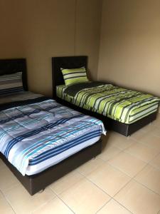 two beds sitting next to each other in a room at The State Apartment in Bangkok