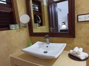 a bathroom with a sink and a mirror and towels at Butterfly Jewel in Unawatuna