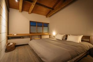 a bedroom with a large bed with a window at Bed and Craft RoKu in Nanto