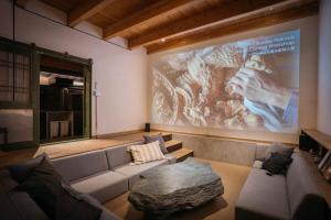 a living room with a couch and a large screen at Bed and Craft RoKu in Nanto