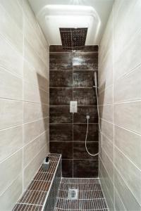 a bathroom with a shower with wooden walls and tiles at Le Terracotta - Appartement privatif in Saint-Denis