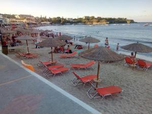 a group of chairs and umbrellas on a beach at Buganvilla Sea View apts in Agia Pelagia