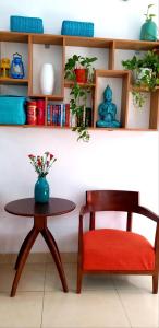 a chair and a table with a vase on a shelf at The Alley Saigon Hotel in Ho Chi Minh City
