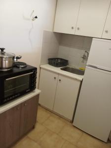 a kitchen with a white refrigerator and a sink at Buganvilla Sea View apts in Agia Pelagia