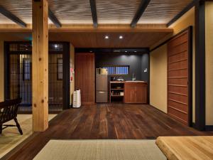 eine Küche mit Holzböden und eine Küche mit Kühlschrank in der Unterkunft Tsumugi Nishinotoinhanayacho in Kyoto