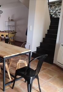 ein Esszimmer mit einem Tisch, Stühlen und einer Treppe in der Unterkunft Duplex à 2km de la Baie de Cancale-Mt St Michel in La Fresnais