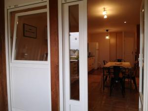 una porta che conduce a una sala da pranzo con tavolo di Duplex à 2km de la Baie de Cancale-Mt St Michel a La Fresnais