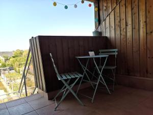 a table and two chairs on a porch with a fence at Grand duplex tout confort, à 2km de la Baie de Cancale - Mt St Michel in La Fresnais +39 photos