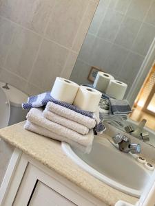 een badkamer met handdoeken en een wastafel met een spiegel bij Peacock Studios in Pefki Rhodes