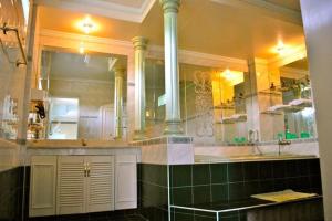 a bathroom with a sink and a large mirror at SM Travelodge in Batangas City