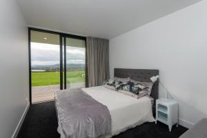 a bedroom with a bed and a view of a golf course at Karapiro BlackBox in Karapiro