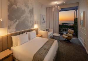 a bedroom with a large bed and a living room at The Marly Boutique Hotel in Cape Town