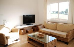 a living room with two chairs and a flat screen tv at Casa Can Relax in Es Pujols