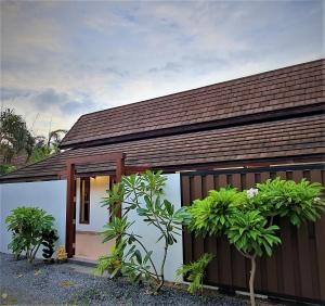 a small house with a brown roof at Orange palm pool villa in Chaweng