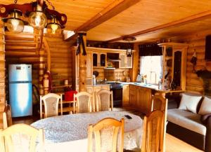 eine Küche und ein Wohnzimmer mit einem Tisch in einer Hütte in der Unterkunft Комфортний котедж в Мигово in Myhowe