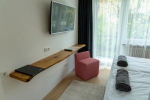 a bedroom with a bed and a desk and a chair at Gästehaus Moßhammer in Graz