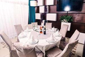 une table blanche avec des chaises et un chiffon de table blanc dans l'établissement Hotel Novak, à Zvornik