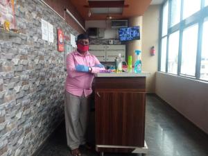 Um homem parado num bar com uma máscara. em Blue Crystal Lodge em Shimoga