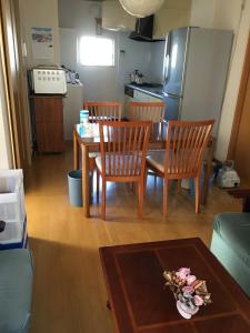 een woonkamer met een tafel en stoelen en een keuken bij 民泊Ｒｉｋａ in Tokai