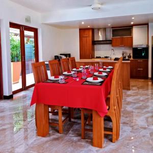 a dining room table with a red table cloth on it at Orange palm pool villa in Koh Samui 