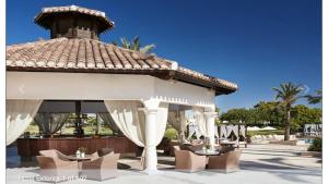 a gazebo at a resort with tables and chairs at Mar Menor Golf Villa - Frontline Detached - Heated Pool in Torre-Pacheco