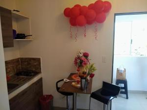 una habitación con una mesa con globos rojos en la pared en apartaestudio parejas 10 mnts del terminal, centro de eventos valle del pacifico y del centro de la ciudad, salida al aeropuerto, en Cali