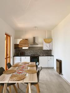 eine Küche mit einem langen Tisch und Stühlen in einem Zimmer in der Unterkunft Happy Guest Apartments - Bella Vista in Riva di Solto