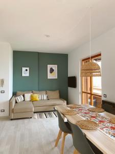 ein Wohnzimmer mit einem Sofa und einem Tisch in der Unterkunft Happy Guest Apartments - Bella Vista in Riva di Solto