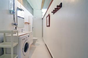 a white bathroom with a washer and dryer in it at Apartamento con piscina y excelentes vistas in Ferrol