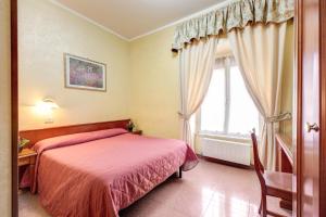 a bedroom with a pink bed and a window at Hotel Milo in Rome