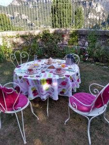 a white table with chairs and a table with food on it at Au Relais Fleuri in Gilette