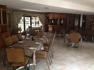 un comedor con una mesa larga y sillas en The Waterfront Country Lodge, en Vaalview