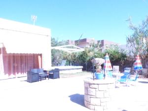 a patio with chairs and umbrellas and a table at Katerinas Place in Analipsi