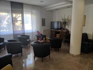 a waiting room with chairs and a flat screen tv at Hotel Luana in Chianciano Terme