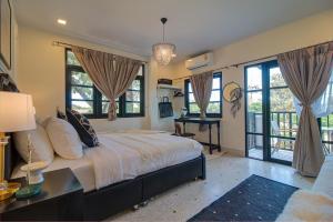 a bedroom with a large bed with windows at Rattana House Homestay in Koh Samui