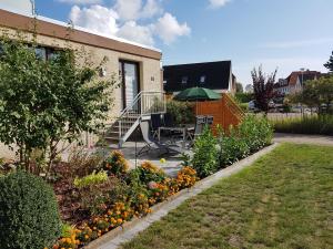 einen Garten mit einem Tisch und einem Sonnenschirm in der Unterkunft Appartementhaus Diana in Grömitz