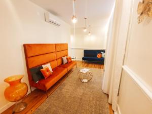 a living room with an orange couch and a blue couch at Le Premier Lisbon Suites in Lisbon