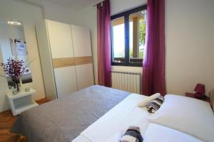 um quarto com uma cama grande e cortinas roxas em Two-Bedroom Apartment Crikvenica near Sea 6 em Dramalj