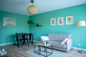 - un salon avec des murs bleus, un canapé et une table dans l'établissement Le Colibri - Stationnement gratuit - Balcon - Jusqu'à 4 personnes, à Metz