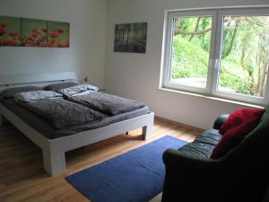 a bedroom with a bed and a window and a couch at Ferienwohnung in Waldrandlage in Zierenberg